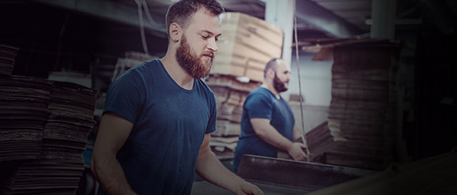 Image of two bearded frontline workers operating in a factory.