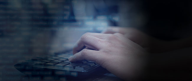A close-up image of hands typing on a keyboard